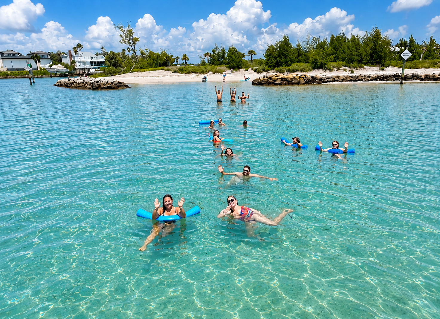 Group swimming and floating in crystal clear turquoise sandbar water